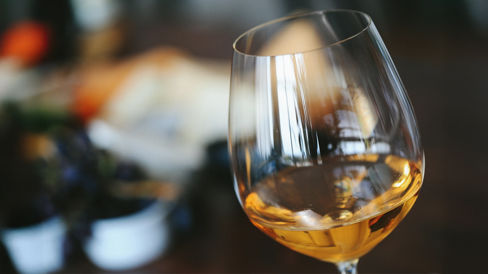 Oranje wijn Elegant glas oranje wijn met culinaire setting op de achtergrond, symbool voor genieten van wijn en gastronomie