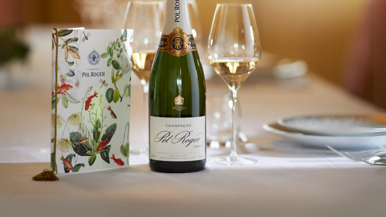 Fles Pol Roger Champagne op tafel met menukaart en wijnglas