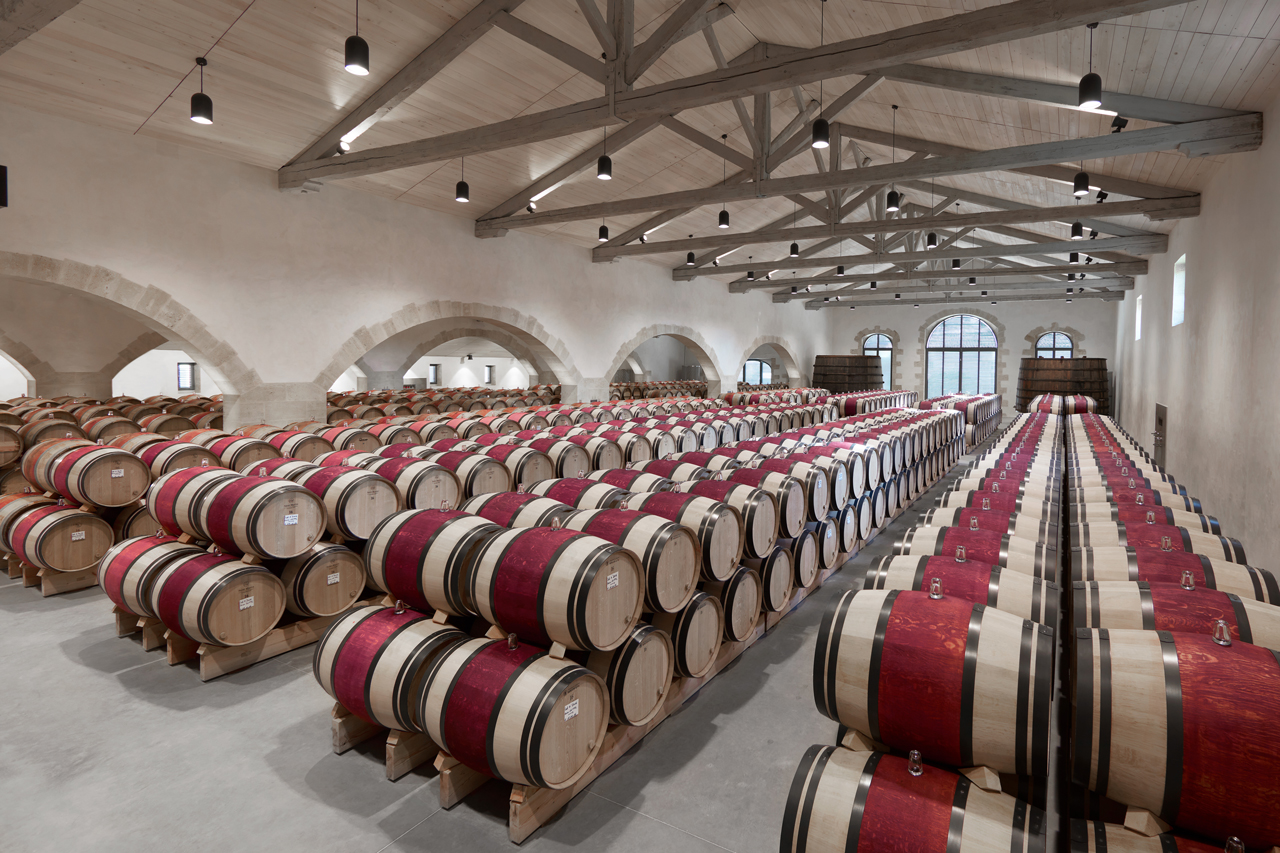 Lange rijen met wijnvaten in de kelder van wijnhuis Calon Ségur, Bordeaux